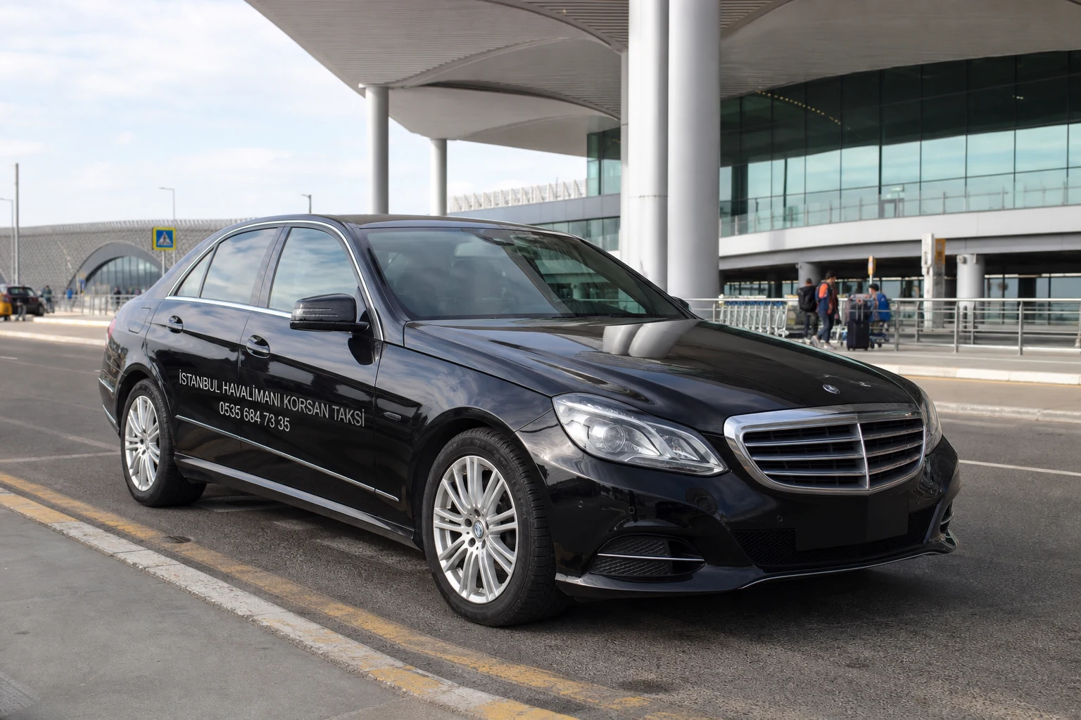 Üzerinde 0535 684 73 35 numarası bulunan İstanbul Havalimanı geliş katındaki koyu renk Mercedes ulaşım aracı